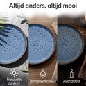 Diepblauwe serveerschaal van aardewerk, getoond in natuurlijk zonlicht, binnenverlichting en avondsfeer.