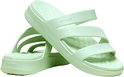 Twee lichtgroene Crocs slippers met drie banden en dikke zolen, op elkaar gestapeld.