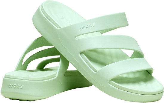 Twee lichtgroene Crocs slippers met drie banden en dikke zolen, op elkaar gestapeld.