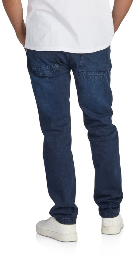 Man in een donkerblauwe regular/straight fit jeans, gezien vanaf de achterkant.