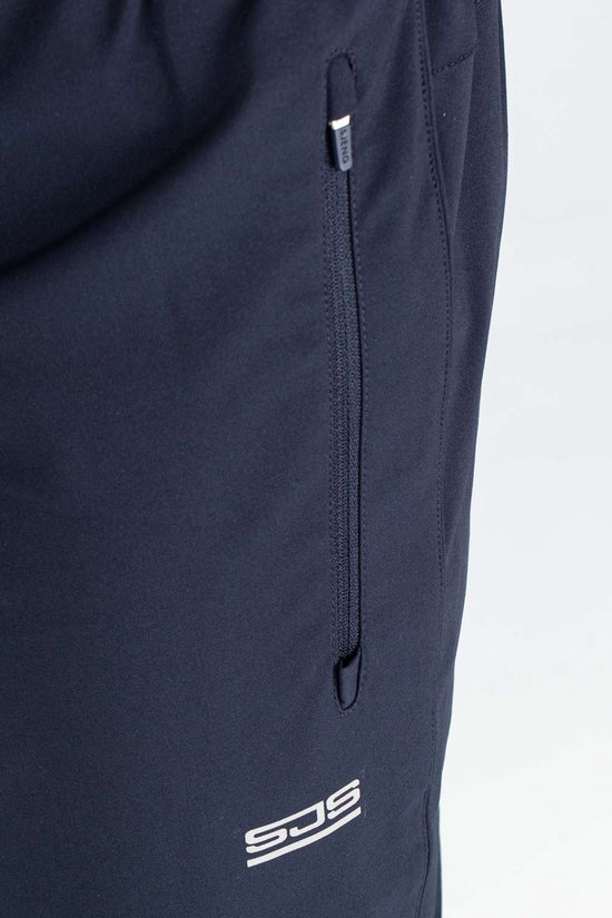 Detail van een donkerblauwe sportbroek met ritszak en logo.