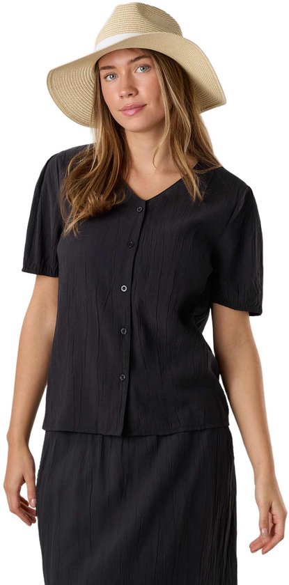 Model in zwarte blouse met knoopjes en strooien hoed met wit lint.