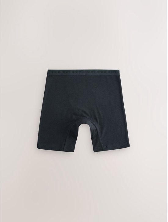 Een donkerblauwe boxer met een elastische band met 'NEXT' en hartjesprint.