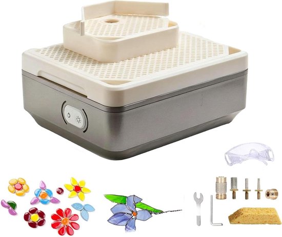 Een witte en grijze glas-in-lood slijpmachine met gereedschap, veiligheidsbril en gekleurde glasstukjes.