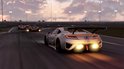 Zilverkleurige Acura NSX GT racewagen met uitlaatvlammen op een circuit.