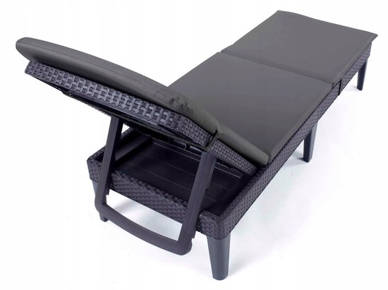 Donkergrijs ligbed met gevlochten frame en kussen, de zitting is omhoog geklapt.
