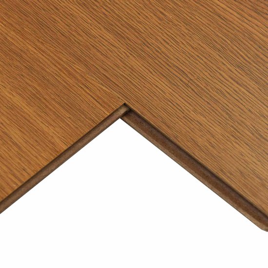 Detail van de zijkant van een goudbruine laminaatplank met kliksysteem.