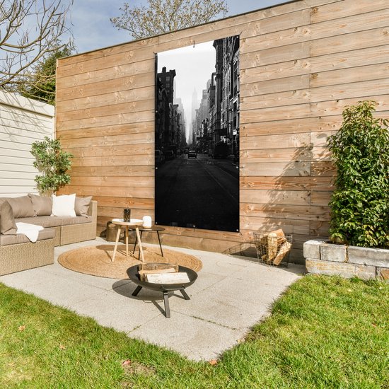 Affiche de clôture Une voiture roule dans une rue calme de New York en noir et blanc - 100x200 cm - Toile jardin
