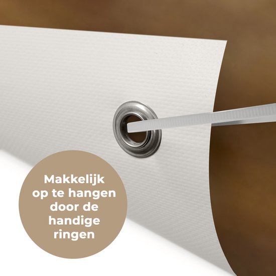 Close-up van een metalen ring en witte stof met textuur, die de bevestigingsmogelijkheden van een tuinposter toont.