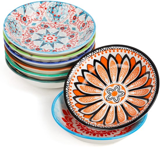 Pile de bols colorés aux motifs orientaux variés. Un bol présente des motifs floraux orange et noirs.