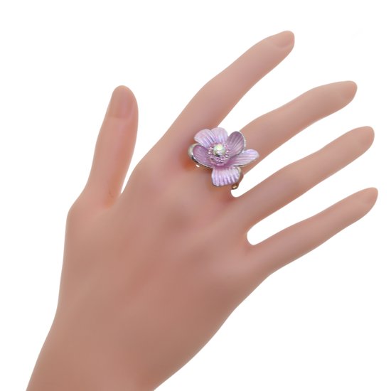 Zilveren ring met een lichtroze bloem met parel in het midden, gedragen op een hand.