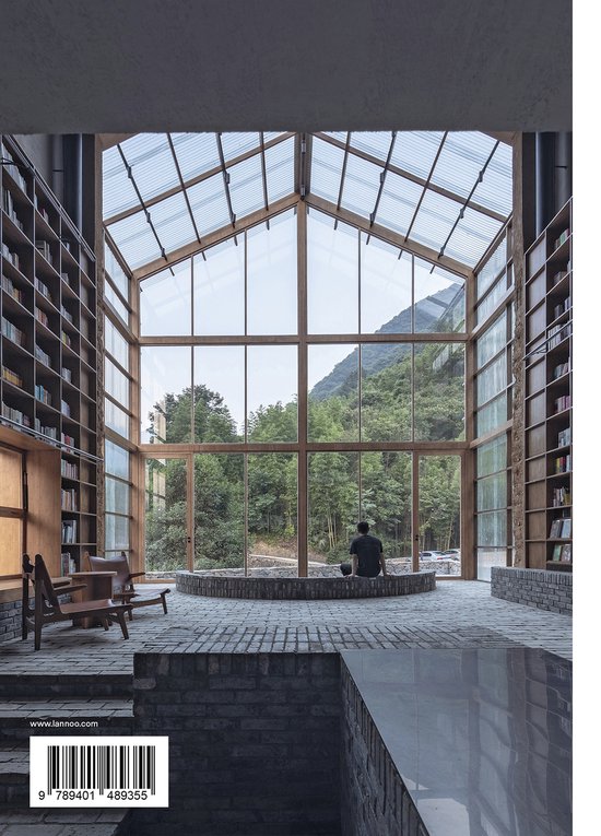 Man zit in een grote, lichte bibliotheek met hoge boekenkasten en een glazen dak met uitzicht op bergen.