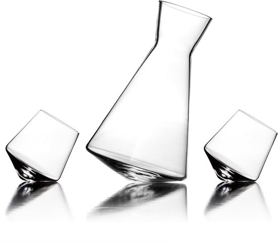 Glazen karaf met twee glazen ernaast, op een reflecterend oppervlak.