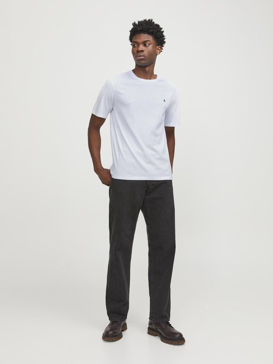 Witte T-shirt met korte mouwen en een klein zwart logo op de borst, gedragen door een man.