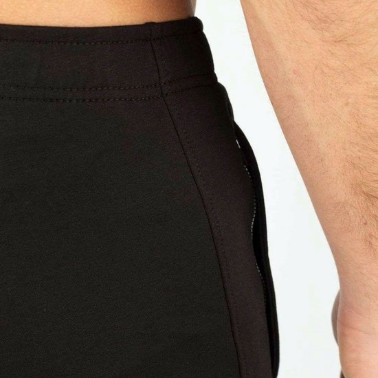 Detail van de tailleband van een zwarte joggingbroek.