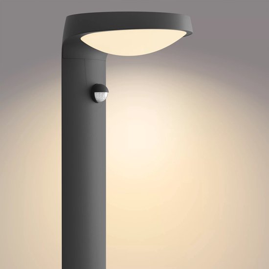 Gedetailleerde foto van een antracietkleurige sokkellamp met warme verlichting en een bewegingssensor.