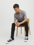 Man zittend op stoel met strakke zwarte jeans