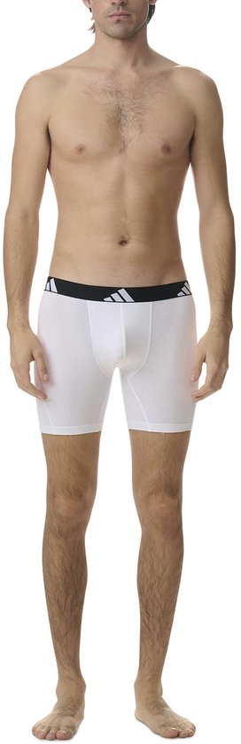 Man met witte boxer met zwarte Adidas tailleband.