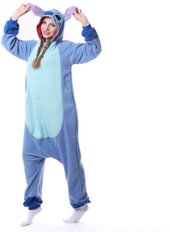 Vrouw in blauwe Stitch onesie met capuchon en uitgestrekte armen, lachend.