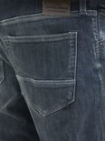 Detail van de achterzak van een donkere jeans met kenmerkende stiksels.