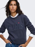 Close-up van een donkerblauw katoenen sweatshirt met de letters "PARIS" in reliëf en een klein rood hartje.
