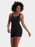 Vrouw draagt een zwart Speedo-badpak met pijpjes, driekwart aanzicht.