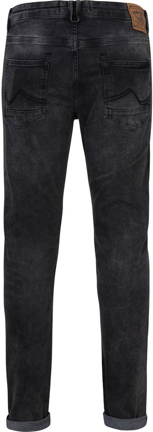Achterkant van een gedragen zwarte slim fit jeans met opgerolde broekspijpen en licht verbleekte wassing.