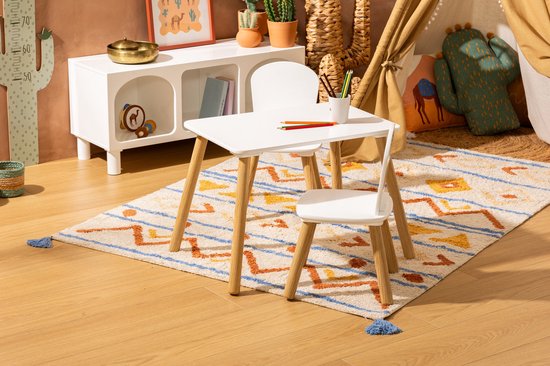 Witte kindertafel met twee stoeltjes, geplaatst op een kleurrijk tapijt in een speelkamer.