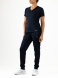 Vrouw in een donkerblauwe sportset. Ze draagt een V-hals T-shirt met korte mouwen en een bijpassende trainingsbroek.