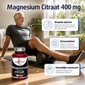 Man doet sportoefeningen met rol en fles magnesium citraat, 400 mg. Info over spieren, zenuwstelsel en geestelijke veerkracht.