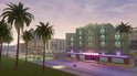 Gebouw met "OCEAN VIEW" in neonletters, met palmbomen en een strandweg.