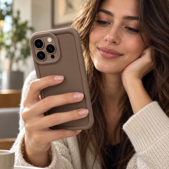 Vrouw met een matbruin iPhone-hoesje voorzien van een verhoogde rand voor de camera.