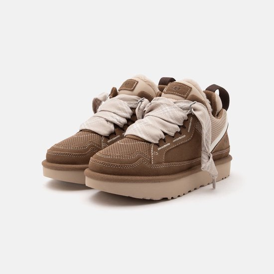 Schuin vooraanzicht van een paar bruine UGG Lowmel sneakers met suède en mesh, op een platformzool.