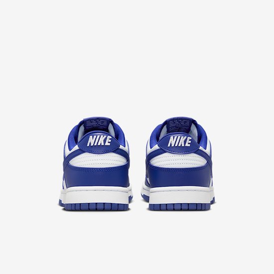 Achteraanzicht van de Nike Dunk Low met witte NIKE-tekst op blauwe hiel.