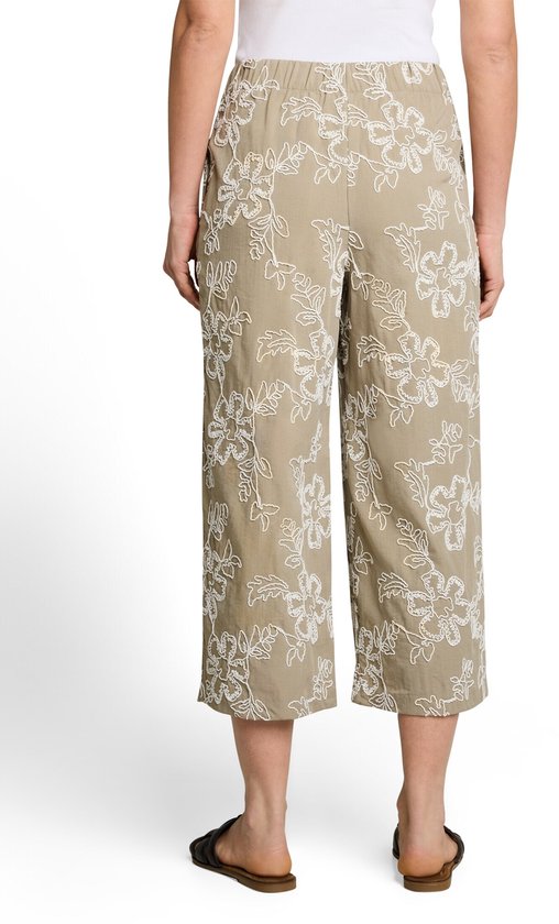 Beige culotte met witte bloemenborduurwerk, gedragen door een vrouw, achterkant.