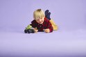 Jongen ligt op de grond met LEGO monster truck, Hulk en Thanos minifiguren.