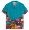 Chemise turquoise à manches courtes, avec un imprimé de coraux colorés et d'animaux marins en bordure inférieure.