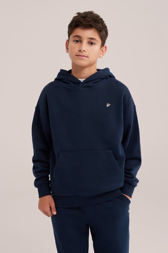 Jongen draagt een donkerblauwe hoodie met een geborduurd wit vogel-detail op de borst.