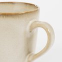 Beige stenen mok met een glad oppervlak en een subtiele bruine rand.