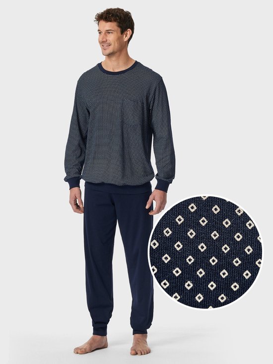 Pyjama in marineblauw met wit stippenpatroon, inclusief een cirkelvormige detailopname van het motief.