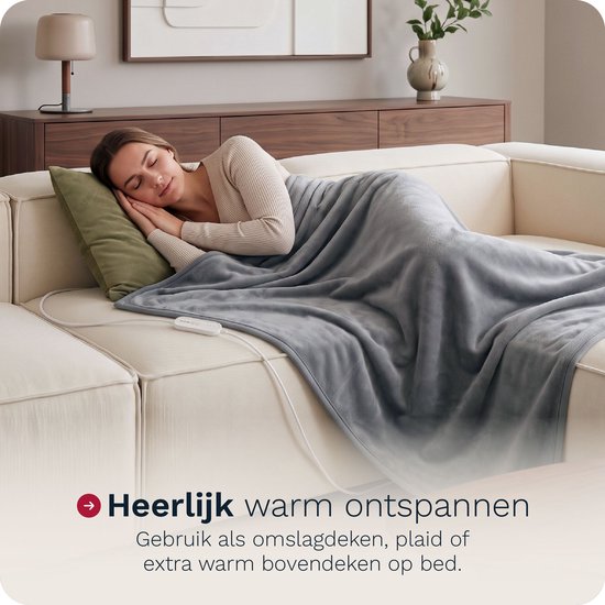 Vrouw ontspant op een bank onder een grijze elektrische omslagdeken, 180x130 cm.