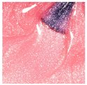 Close-up van een kwastje in glinsterende, perzikroze nagellak met fijne zilveren glitter.