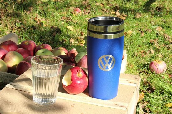 Korenblauwe thermosbeker met VW logo naast een glas water en appels.