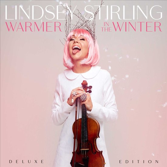 Lindsey Stirling met roze pruik, witte jurk en viool, met de tekst 'Warmer in the Winter Deluxe Edition'.