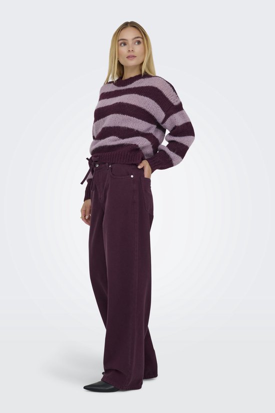 Model met paarse wijde broek met trekkoord en strik. Draagt een paarse en roze gestreepte trui.