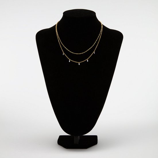 Gouden dubbel collier met kristalhangers, tentoongesteld op een zwarte paspop.