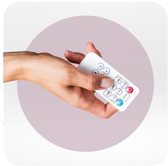 Hand die een witte afstandsbediening vasthoudt met knoppen voor muziek, volume, timer en snelheid.