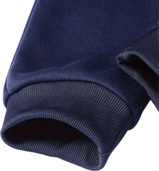 Detail van de zoom van de mouw van een donkerblauw joggingpak.
