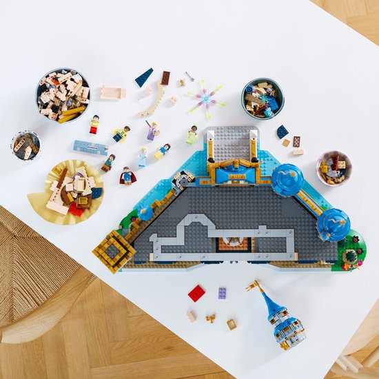 LEGO onderdelen van het Disney Kasteel verspreid op een tafel, met de basis van het kasteel.
