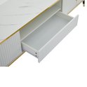 Detail van een open lade in een witte tv-kast met ribbelpatroon en gouden rand.